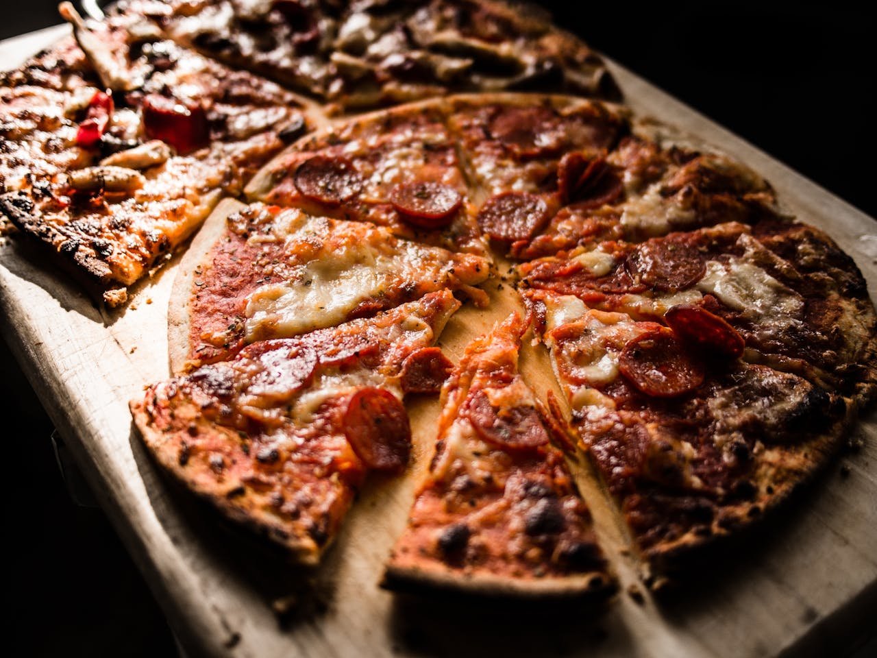menu-02 Delicious crispy pepperoni pizza slices on a wooden board, perfect for pizza lovers.