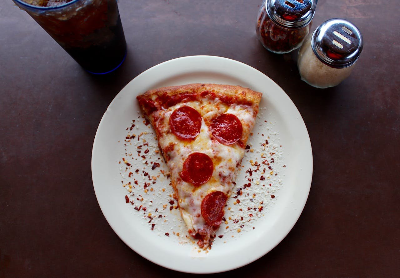 about-03 A mouthwatering slice of pepperoni pizza with cheese and spices, ideal for any meal.